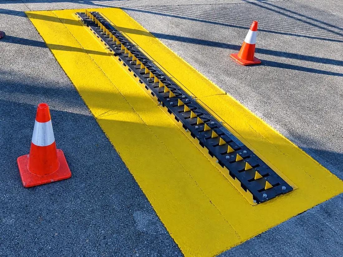 In-ground spike section set in a new concrete pad with a yellow painted surround