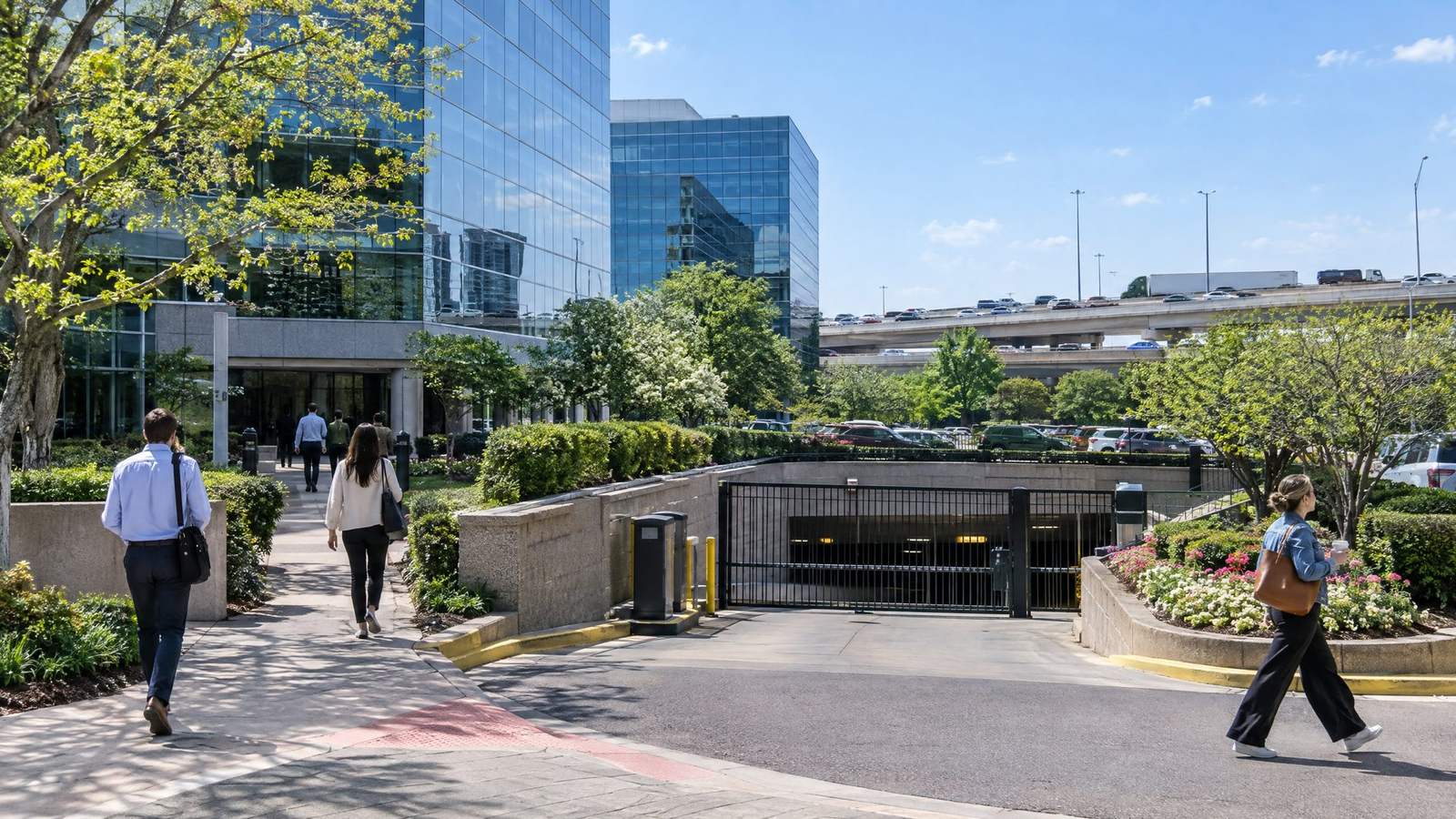 Dallas office tower plaza with a gated parking garage entrance and pedestrians