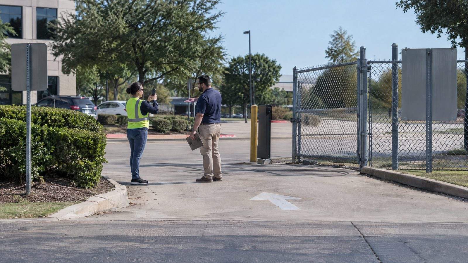 Building inspector photographing a one-way commercial exit while a property manager explains the layout