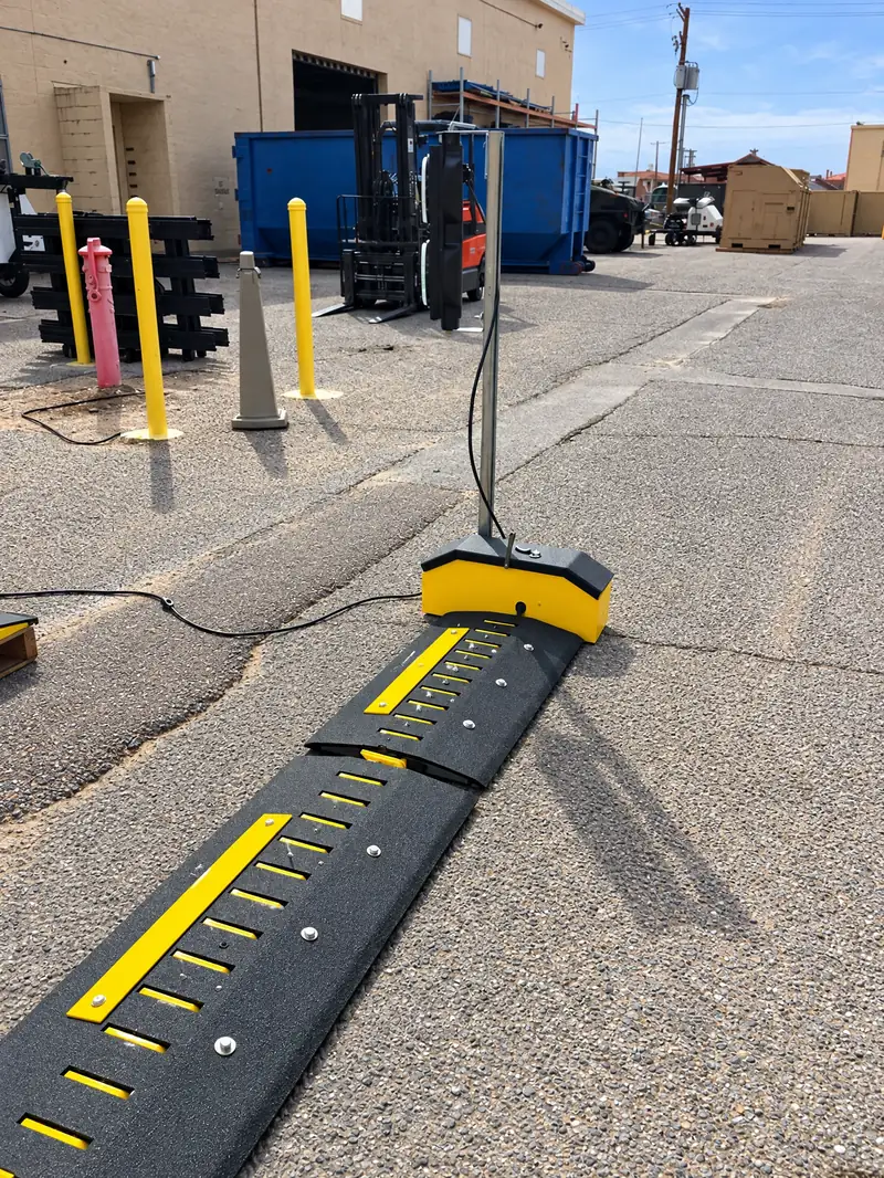 Motorized spike system with its controller housing set up across a yard lane