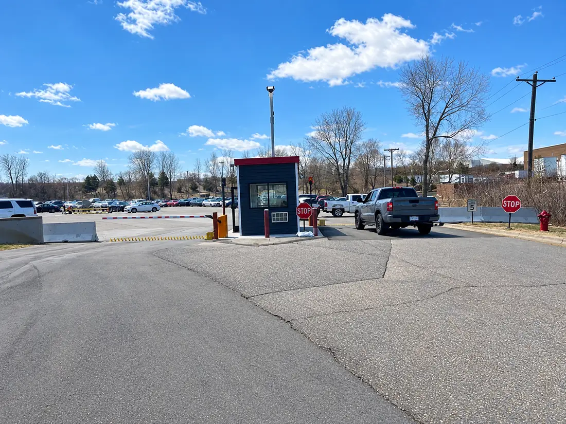 Motorized spike lanes at a guarded parking-lot entry