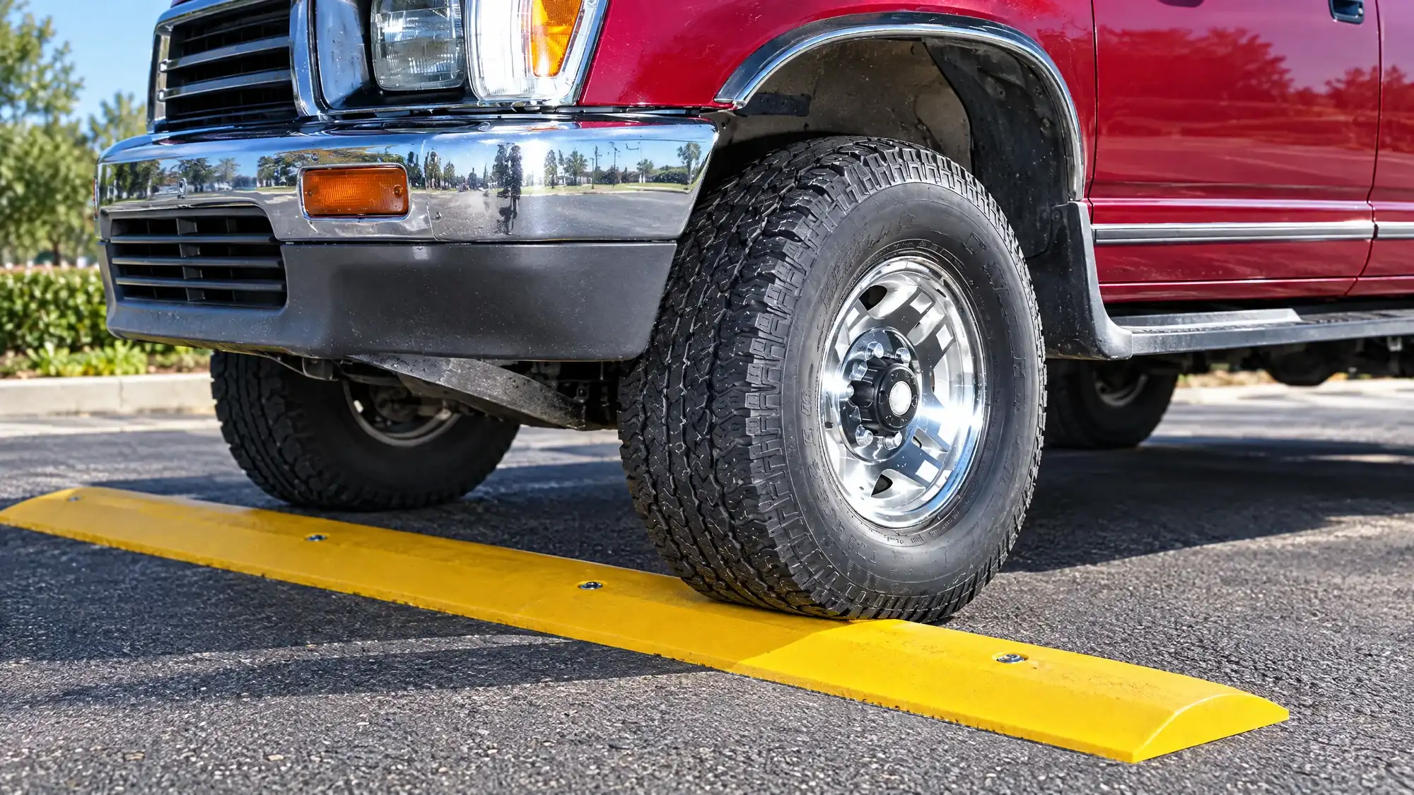Truck tire rolling over a yellow recycled plastic speed bump
